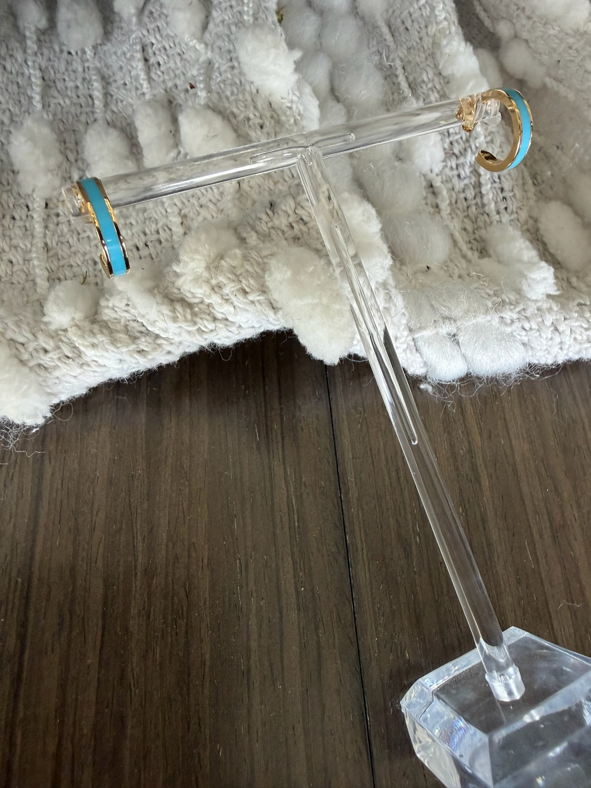 Clear glass earring on a textured white surface