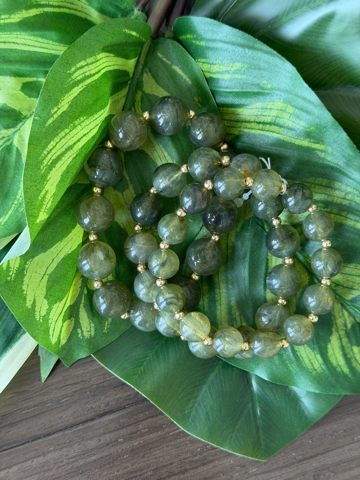 Green beaded necklace on a large green leaf