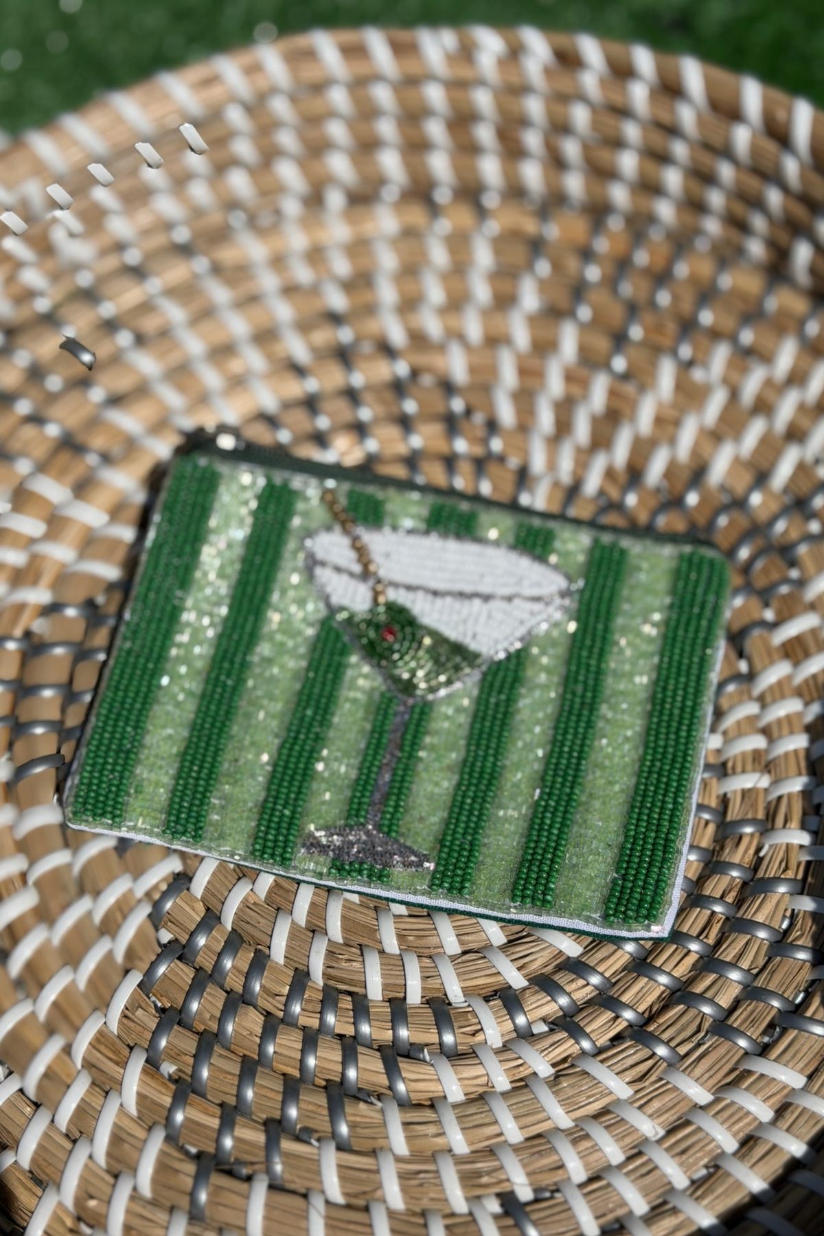 Beaded patch with martini glass design on a woven surface