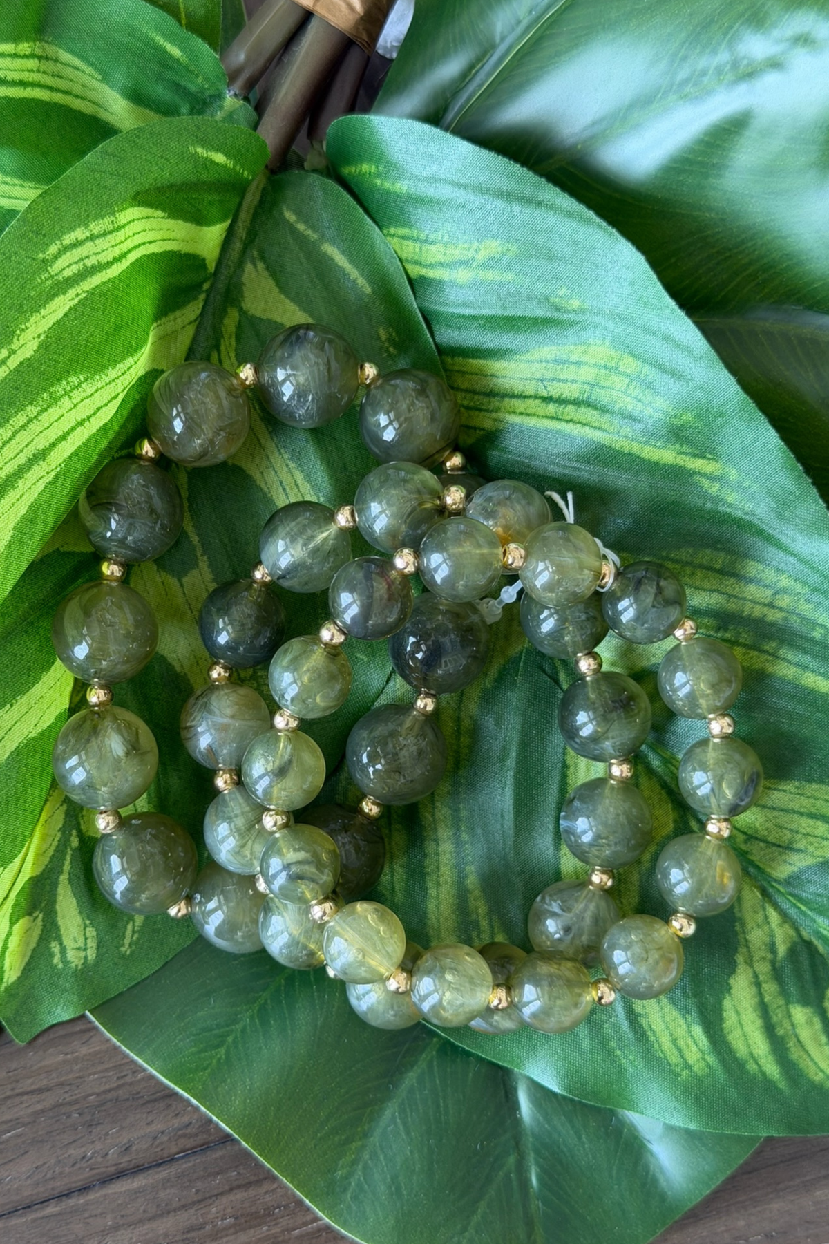 Green beaded bracelet on a large green leaf