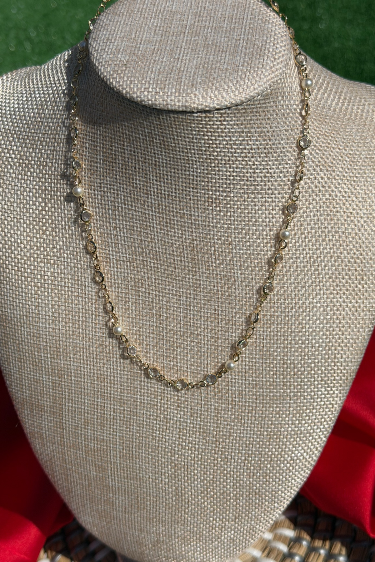 Necklace on a mannequin bust with a red garment underneath