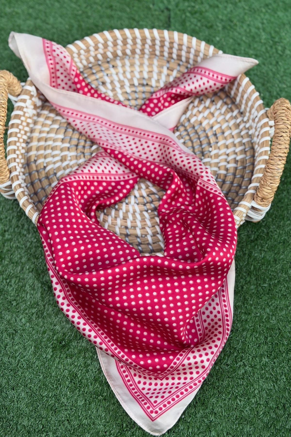 Red and white checkered fabric on a woven basket against a green background