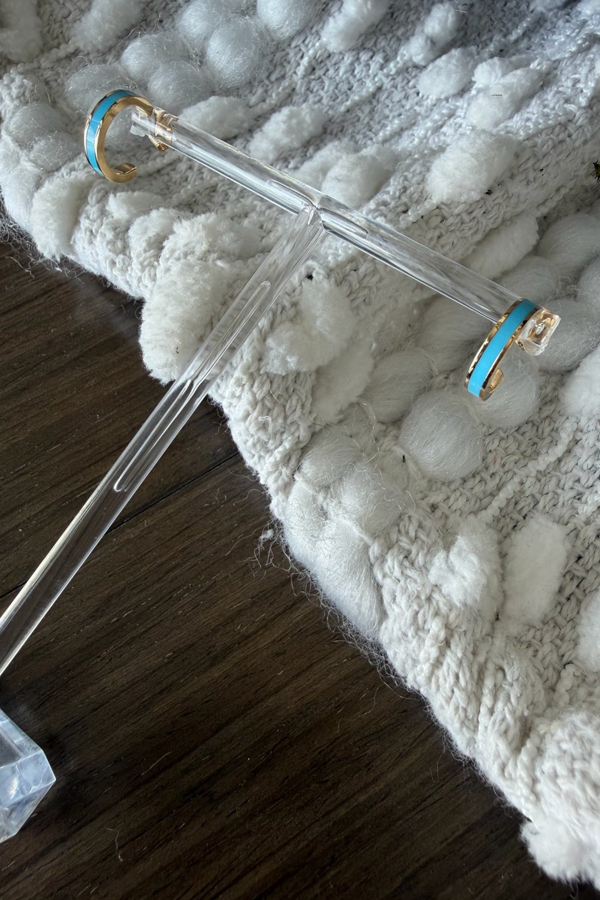 Clear glass rod with gold and blue ends on a textured white surface