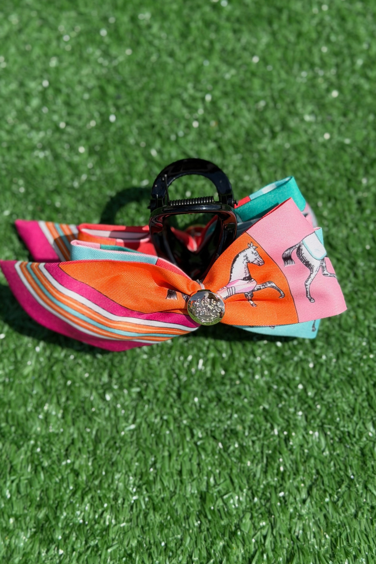 Colorful hair bow with a decorative center on green grass