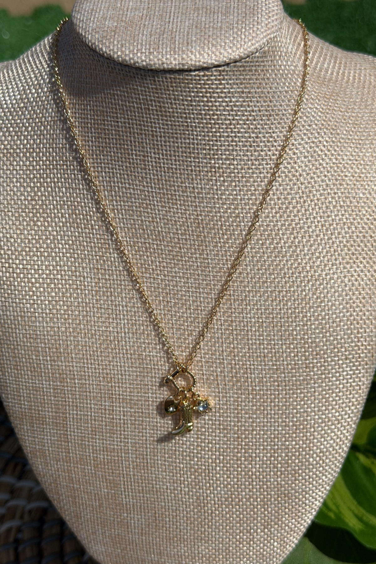 Gold necklace with a pendant on a mannequin bust