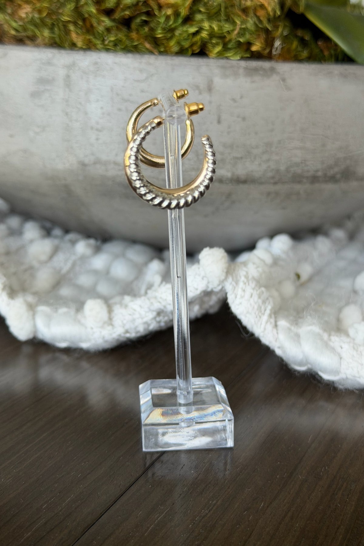 Decorative stand with gold crescent moon and circle design on a wooden surface.