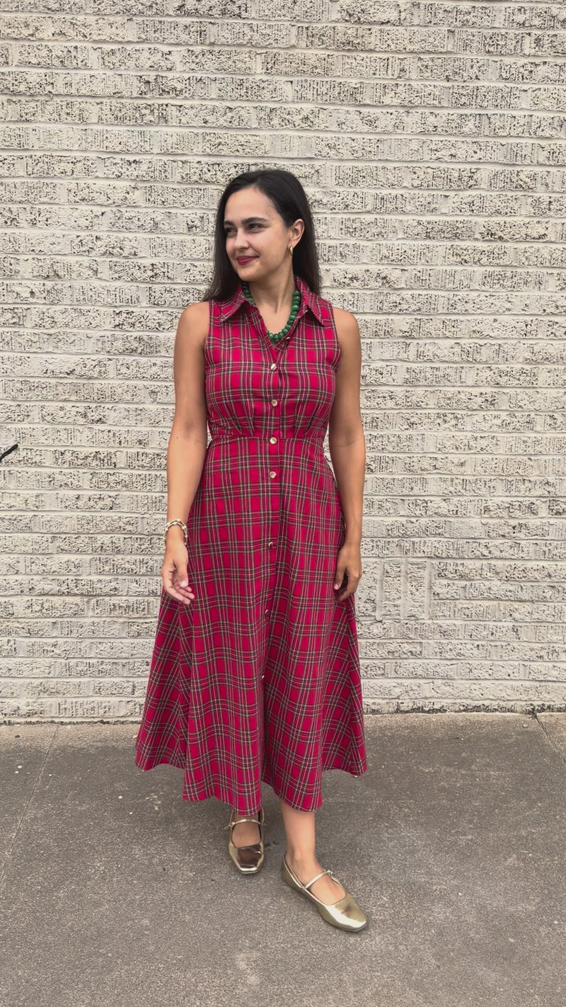 Model wearing the Mistletoe Manor Plaid Maxi Dress in Red Multi, featuring a sleeveless collared neckline, gold-tone button-front detailing, defined waist, and flowing A-line maxi skirt styled with metallic gold ballet flats standing outside. Southern House Clothing