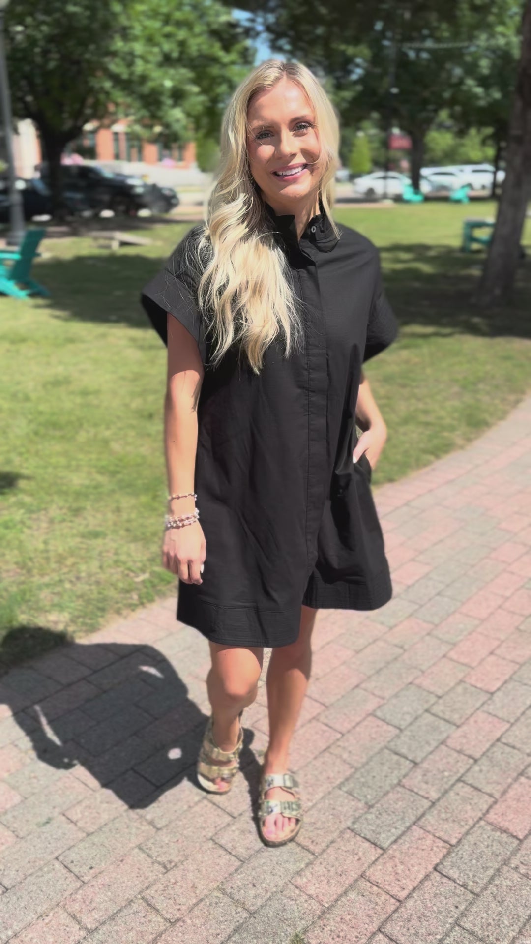 Woman in a black dress on a sidewalk