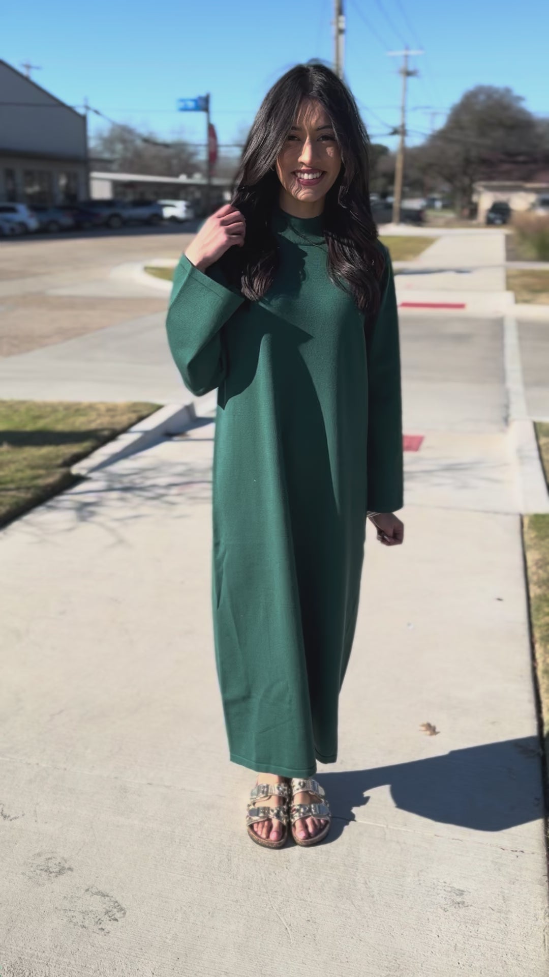 Woman wearing a green dress standing outside.