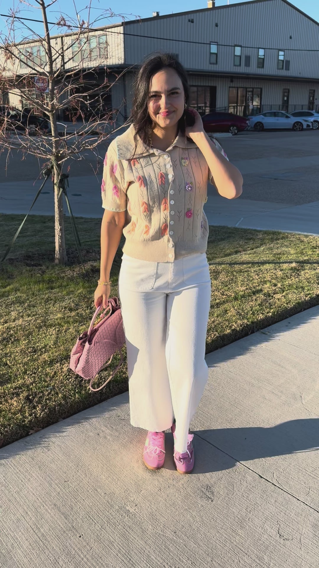 Woman wearing a light-colored blouse with floral patterns in an outdoor setting