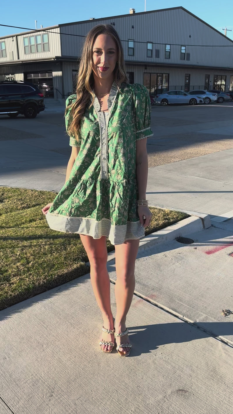 Woman wearing a green floral dress with a blurred background