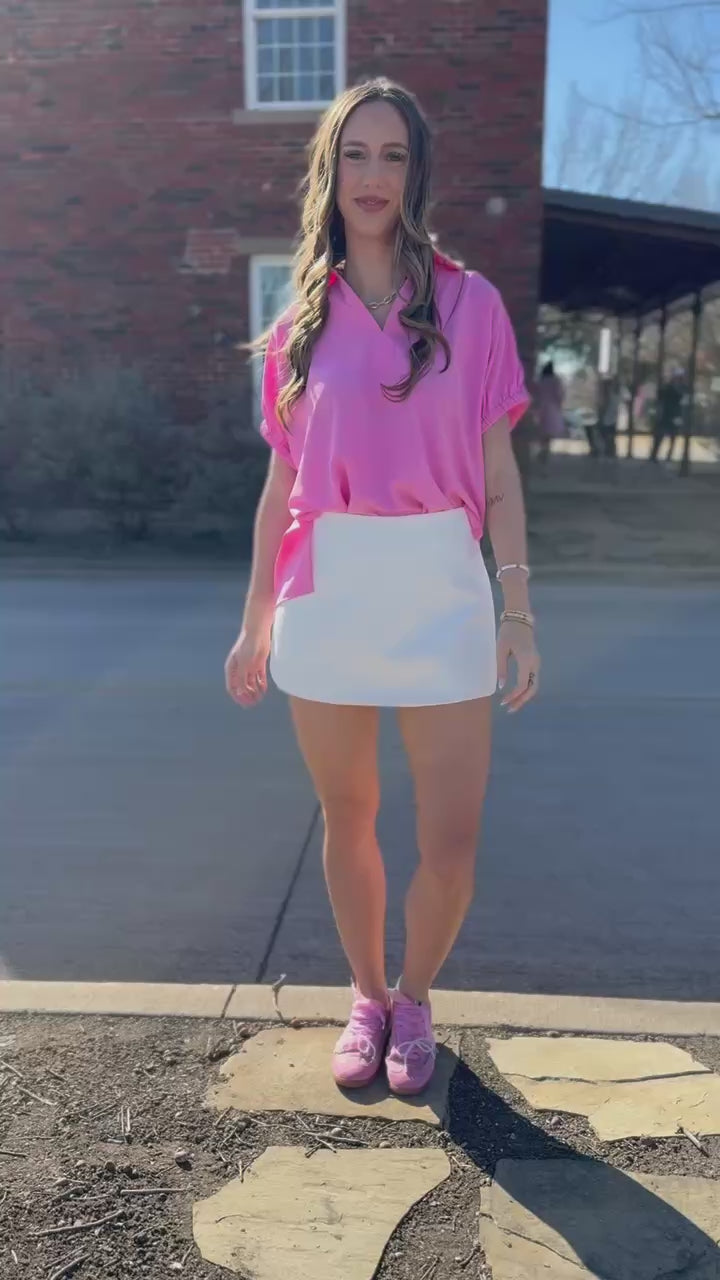 blonde moeld wearin Elevated Chic Collared Blouse – Pink and a white skirt 
