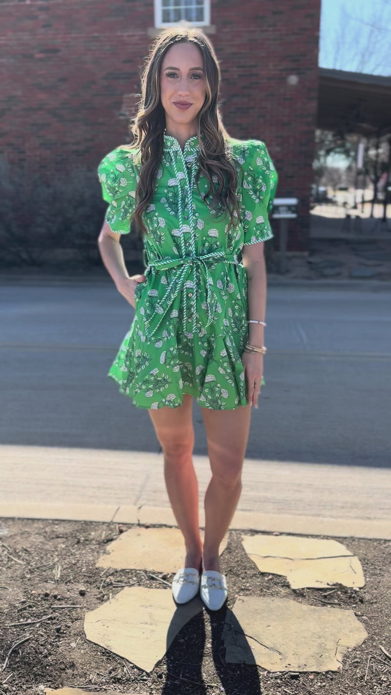 Woman wearing a green floral dress outside.