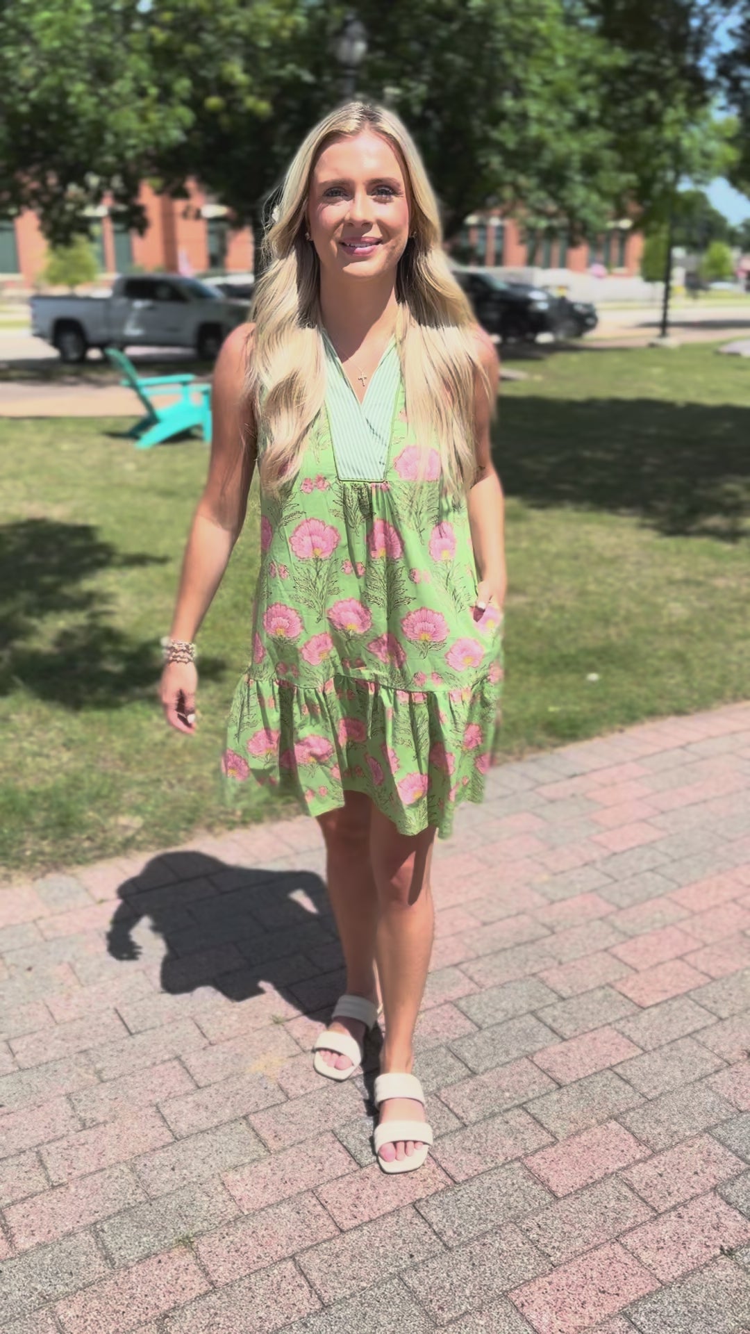 Woman in a green floral dress standing outdoors