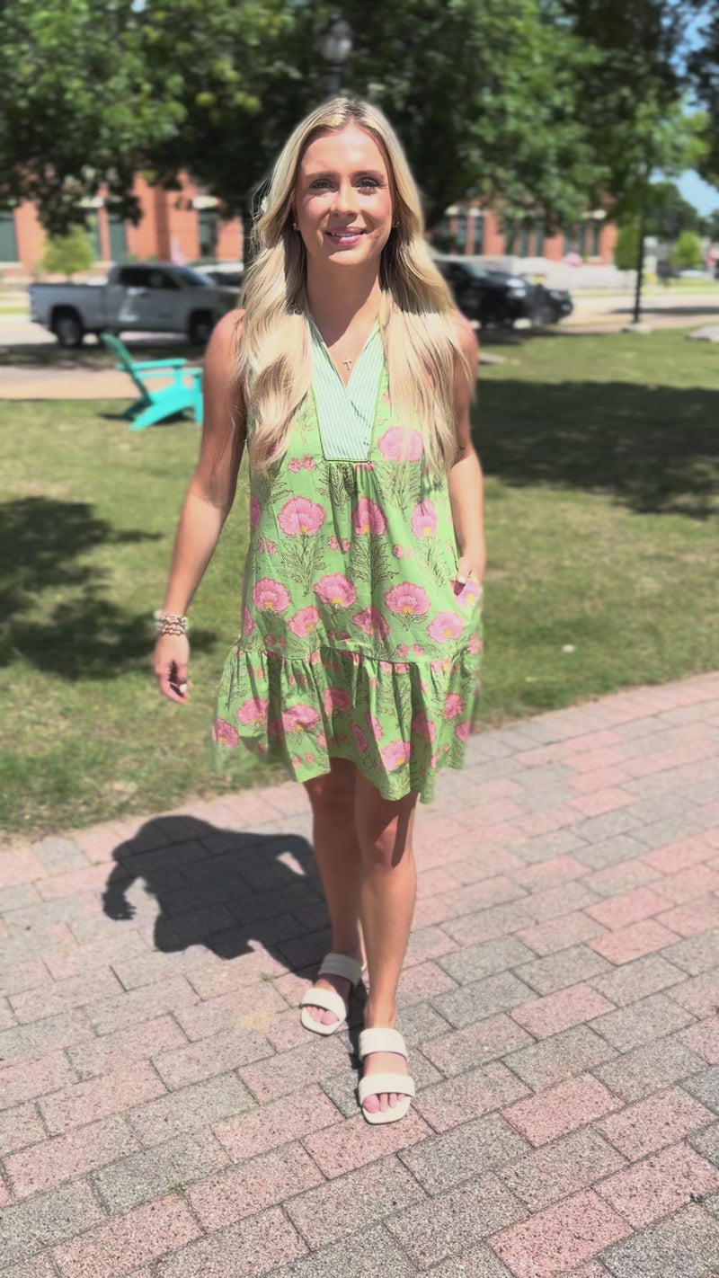 Woman in a green floral dress standing outdoors