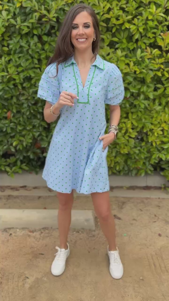 Woman in a light blue dress walking outside.