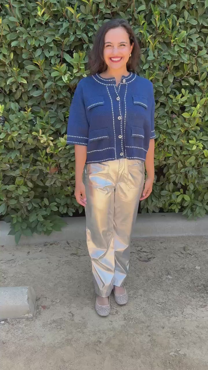 Brunette model wearing a blue sweater top and silver pants in an outdoor setting. Southern House Clothing 