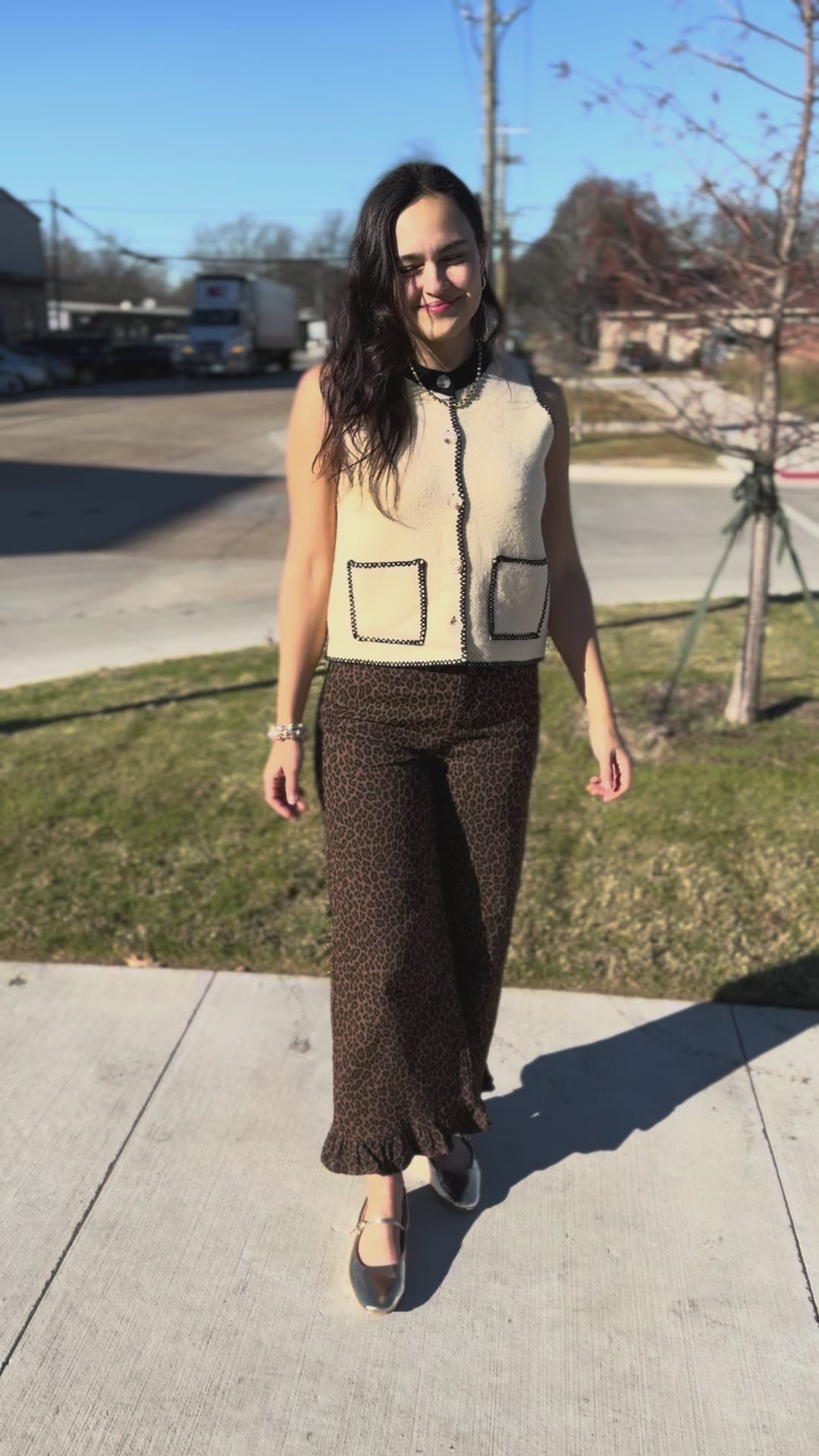 Woman wearing a patterned vest and pants outside