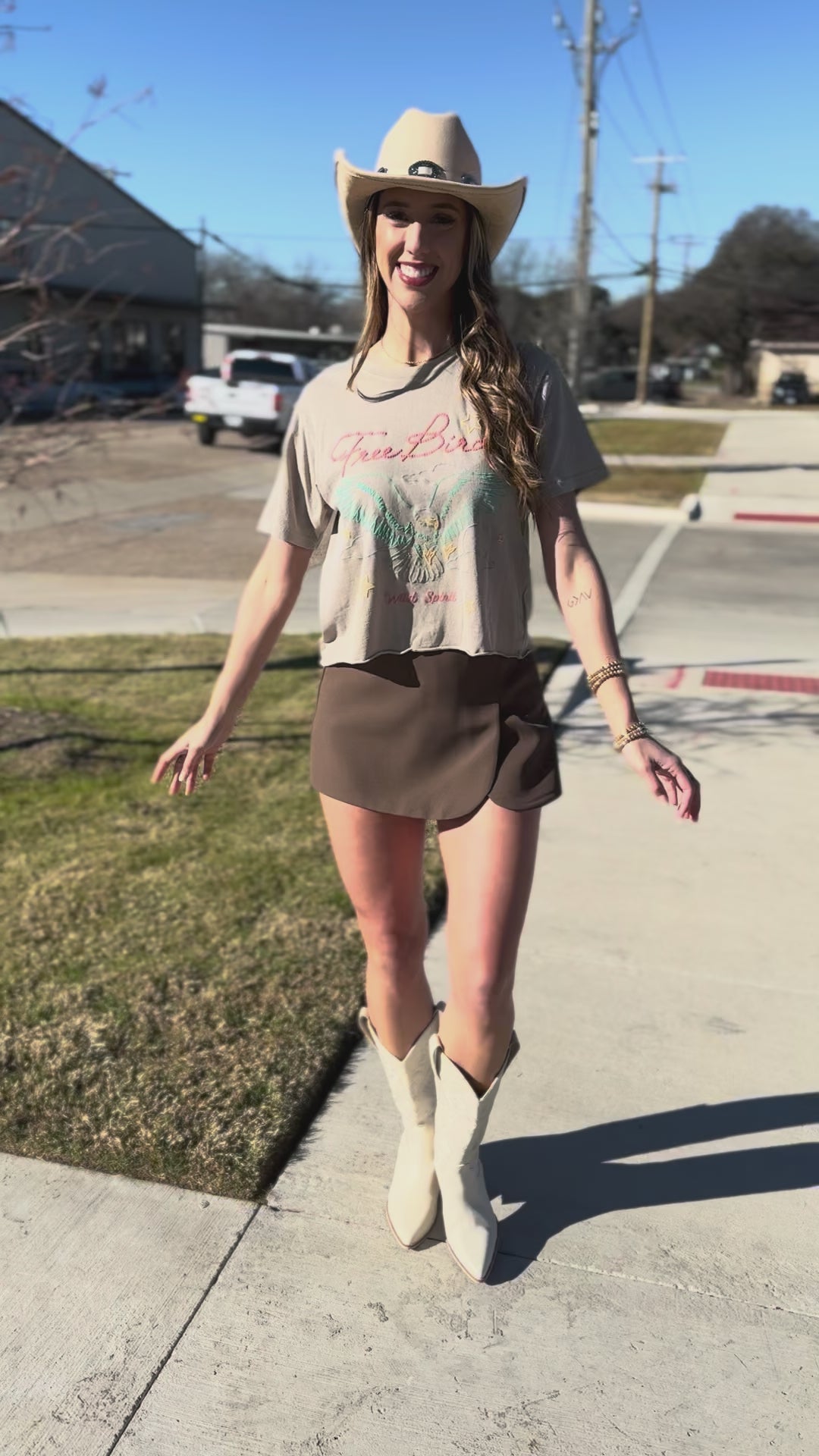 Woman wearing a 'Free Bird' t-shirt with an eagle design outdoors.