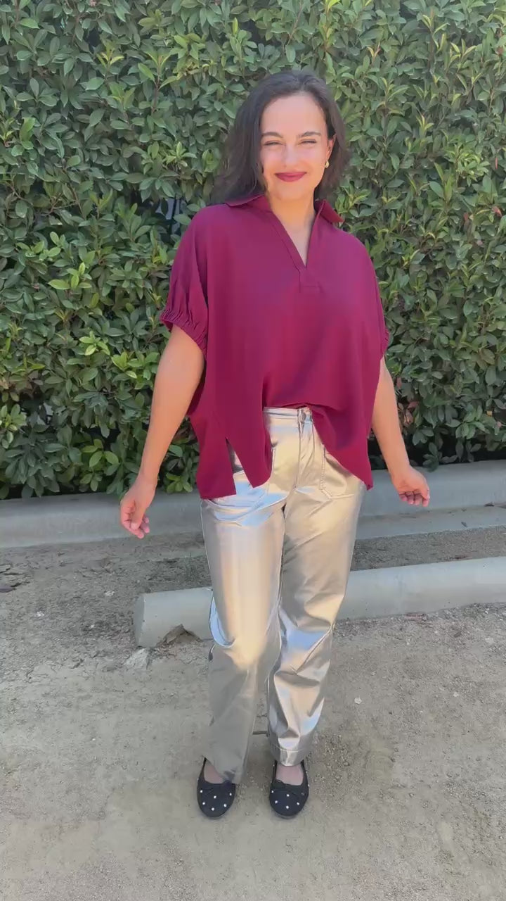Brunette model wearing a burgundy top and silver pants in an outdoor setting. Southern House Clothing 