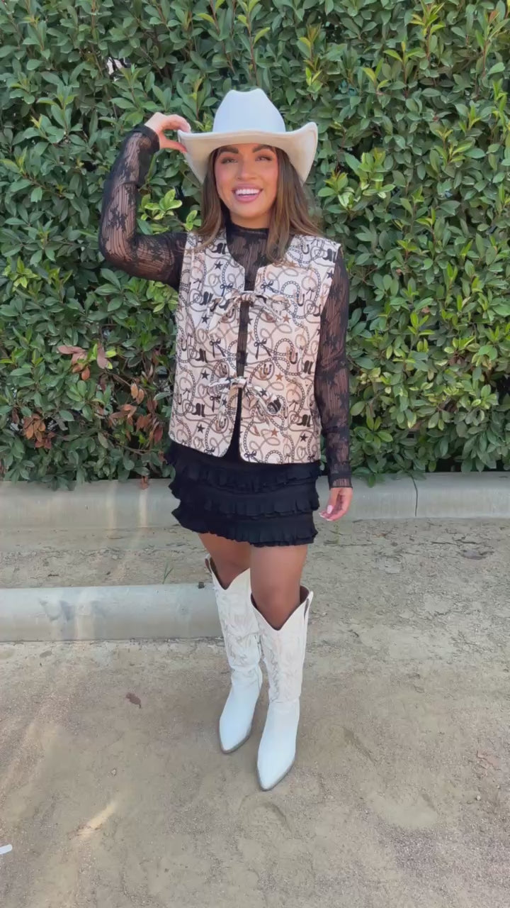 Brunette model wearing a mesh top and vest with a white cowboy hat in an outdoor setting. Southern House Clothing