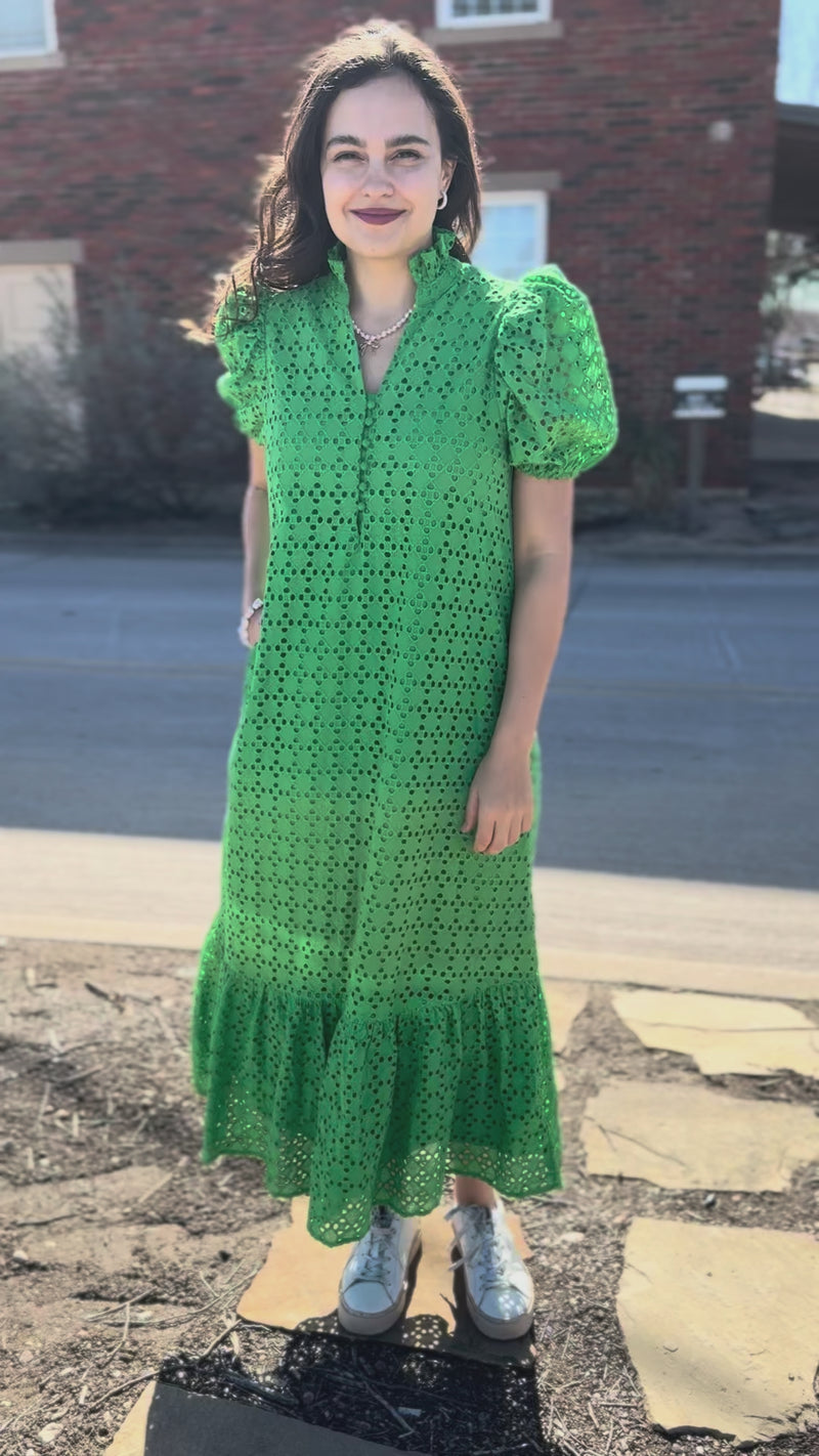 Woman wearing a green dress with a pattern outside.