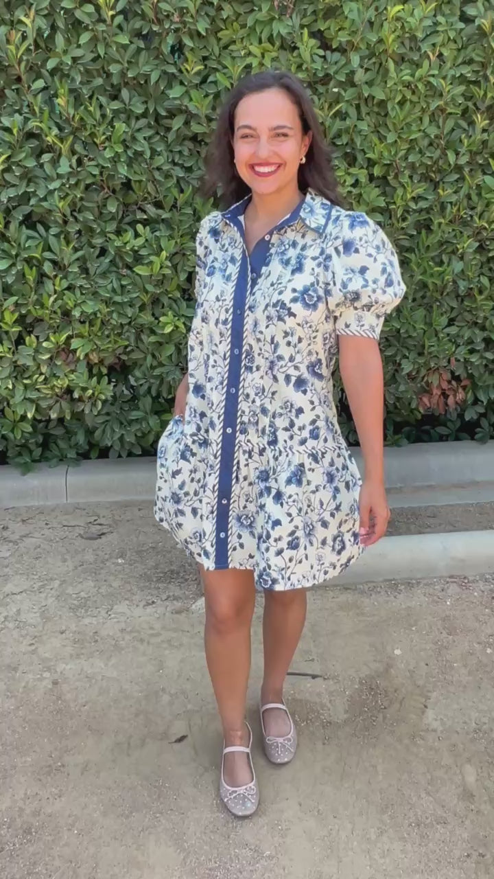 Brunette model in a navy and cream collared dress in an outdoor setting. Southern House Clothing