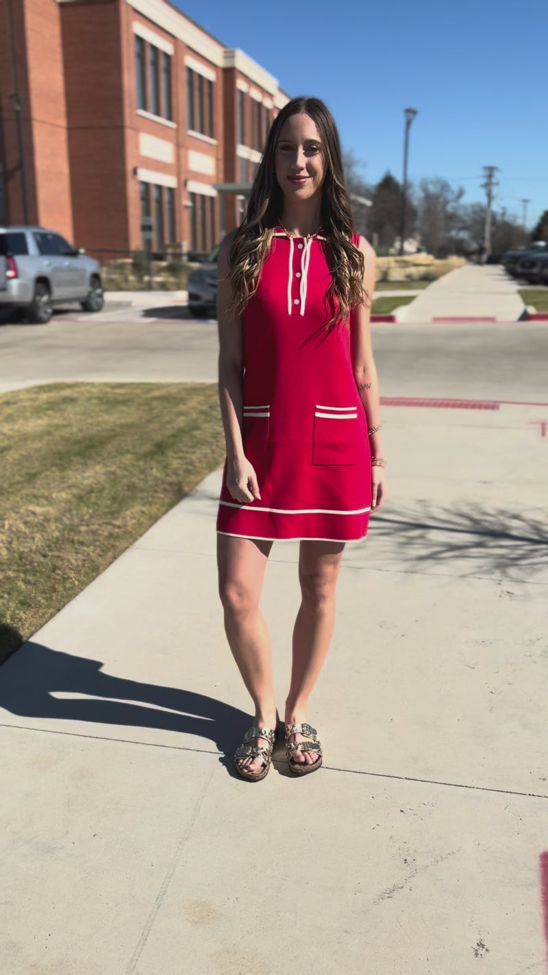 Woman wearing a red dress with white accents outside.