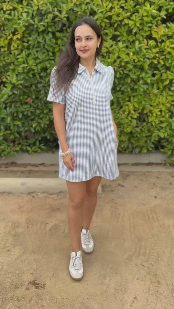 Woman wearing a checkered dress standing outside