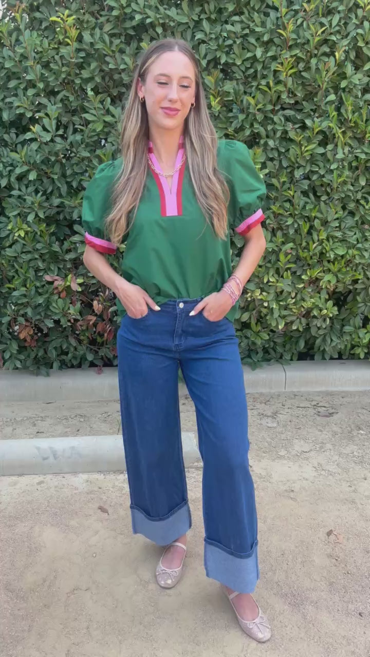 Blond Model in a green top and denim jeans in an outdoor setting. | Southern House Clothing