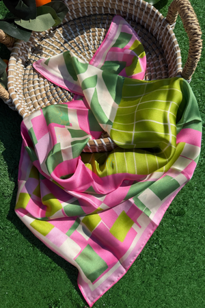 Colorful checkered scarf on a woven basket with green grass background