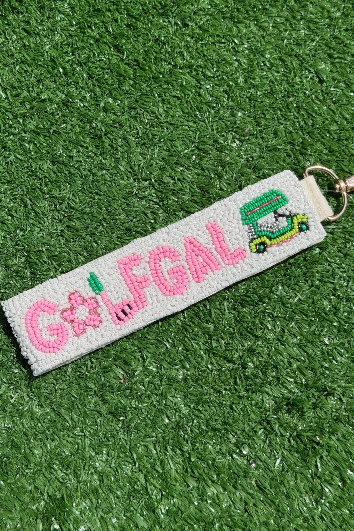 Keychain with 'GOLFGAL' text and golf cart design on a green grass background